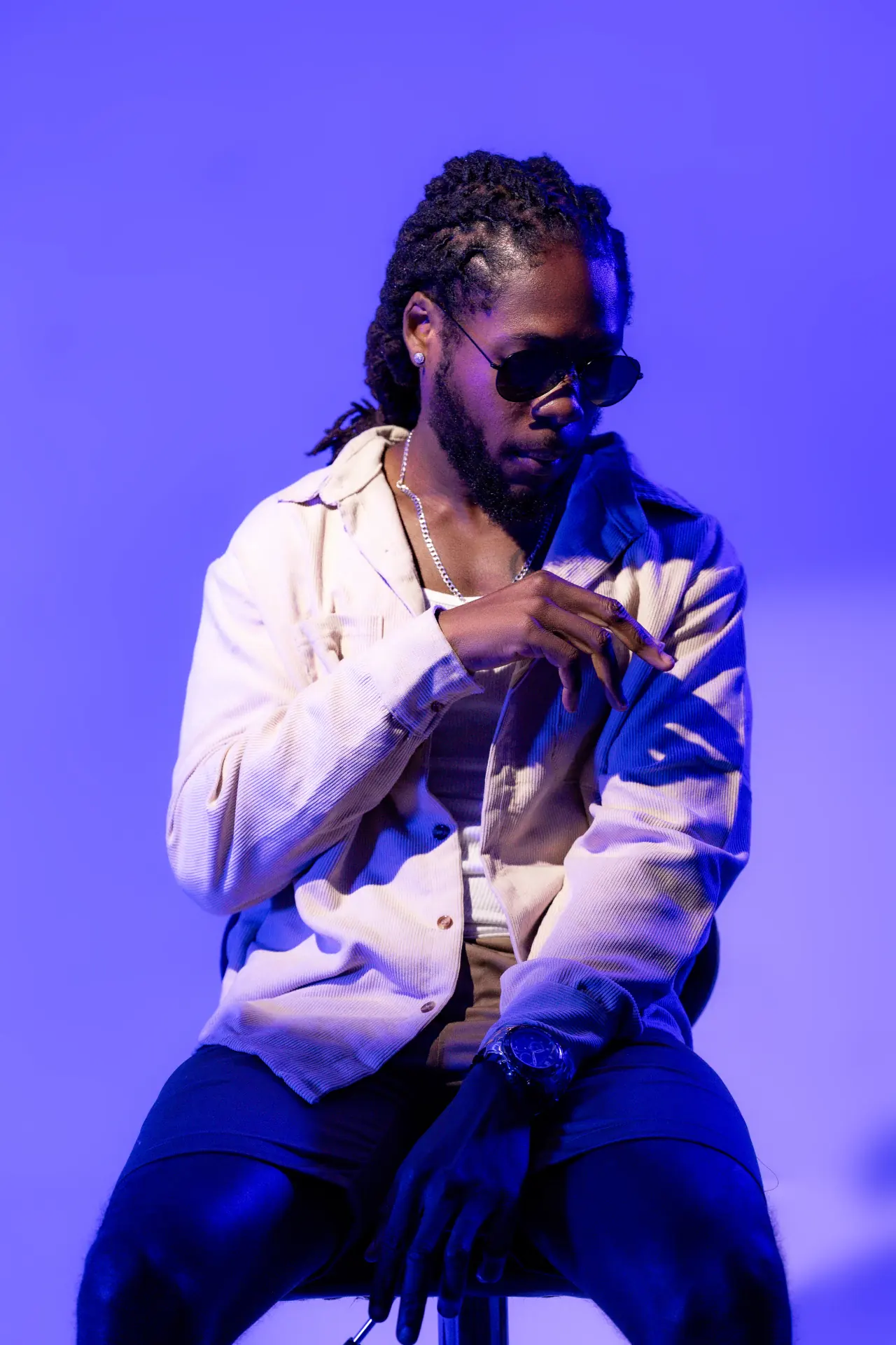Saint Chris standing full-body portrait in blue studio lighting.